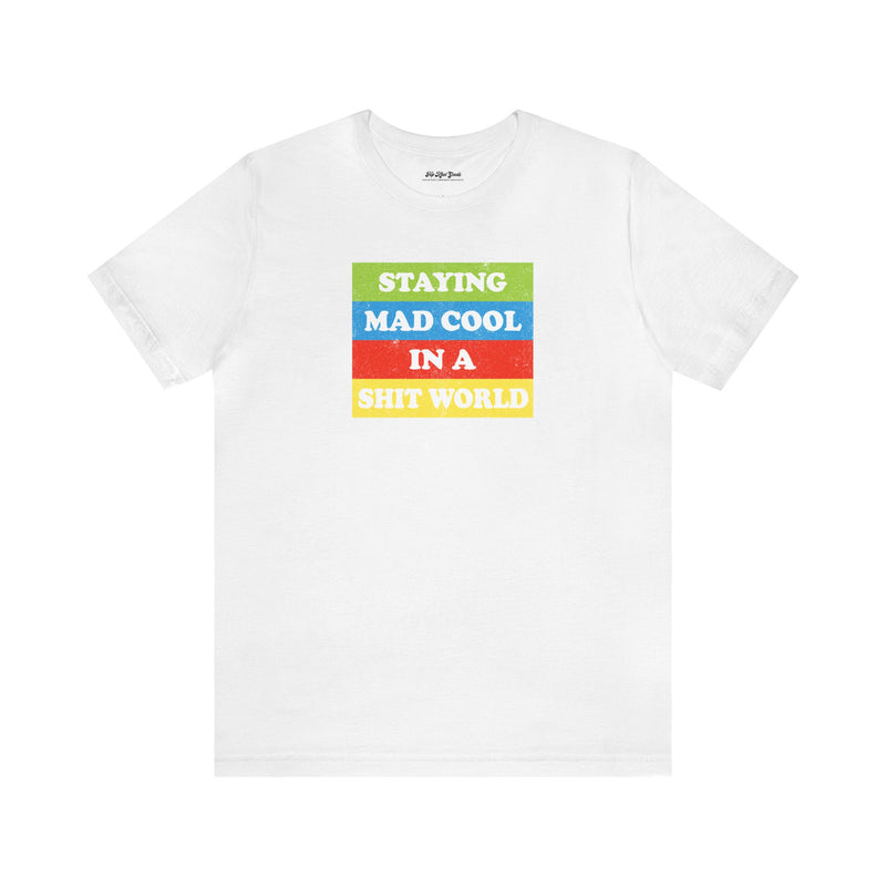 Flat lay of white cotton t-shirt that says Staying Mad Cool in A Shit World.