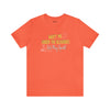 Orange cotton shirt by Top Knot Goods that says Meet Me Under The Bleachers, Lets Play Sports.