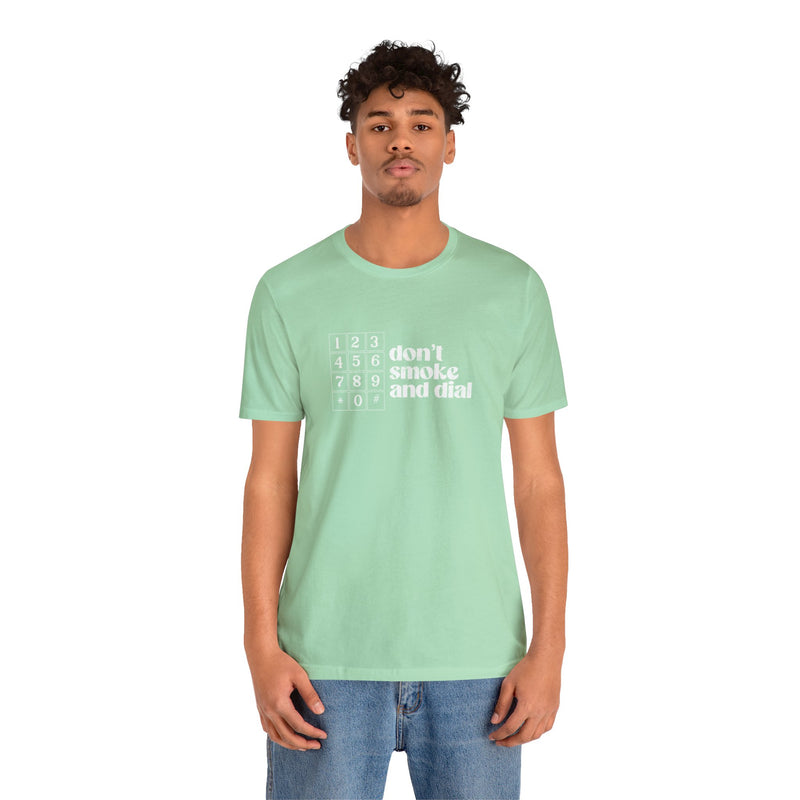 Model wearing a green cotton t-shirt that says Don't smoke and Dial.