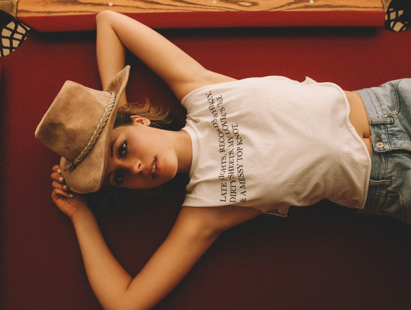 Girl laying on pool table wearing Top Knot Goods white cotton Late Nights and whiskey T-shirt. 
