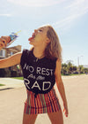Girl drinking juice wearing Top Knot Goods No Rest for the Rad black cotton T-shirt.