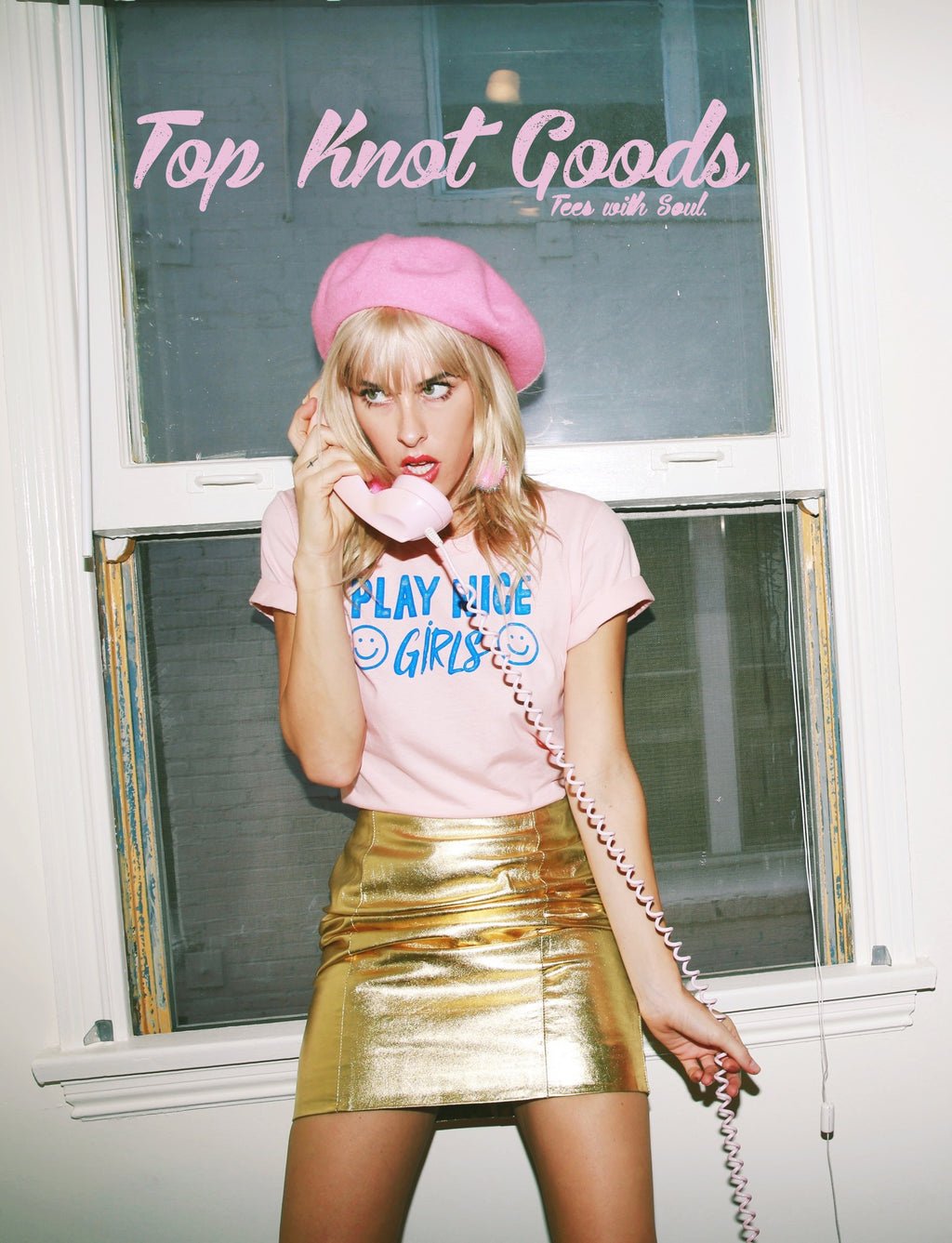 Model wearing pink Play Nice Girls cotton T-Shirt with gold skirt. 