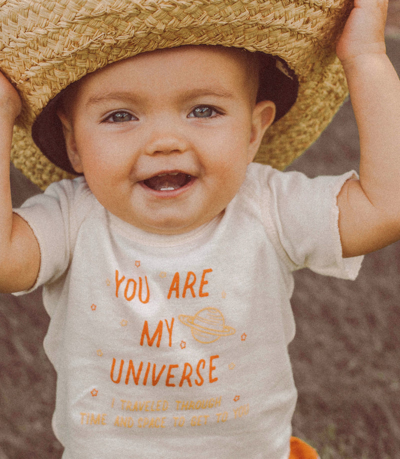 Happy baby wearing You Are my Universe T-shirt. 