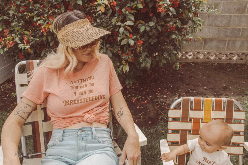 Mother looking at baby sitting in lawn chair 