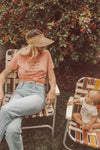 Mother and baby looking at each other while sitting in vintage lawn chairs 