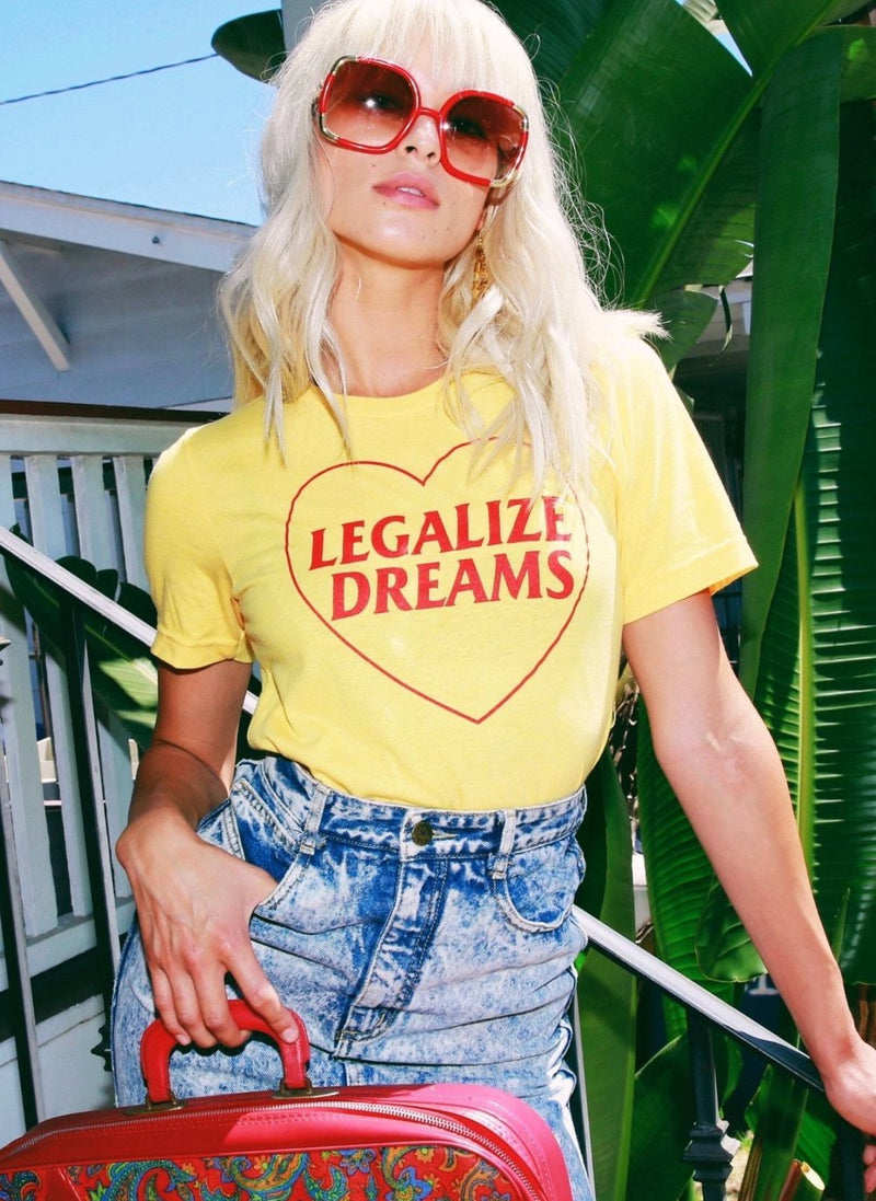 Model wearing sunglasses and yellow vintage Legalize Dreams t shirt