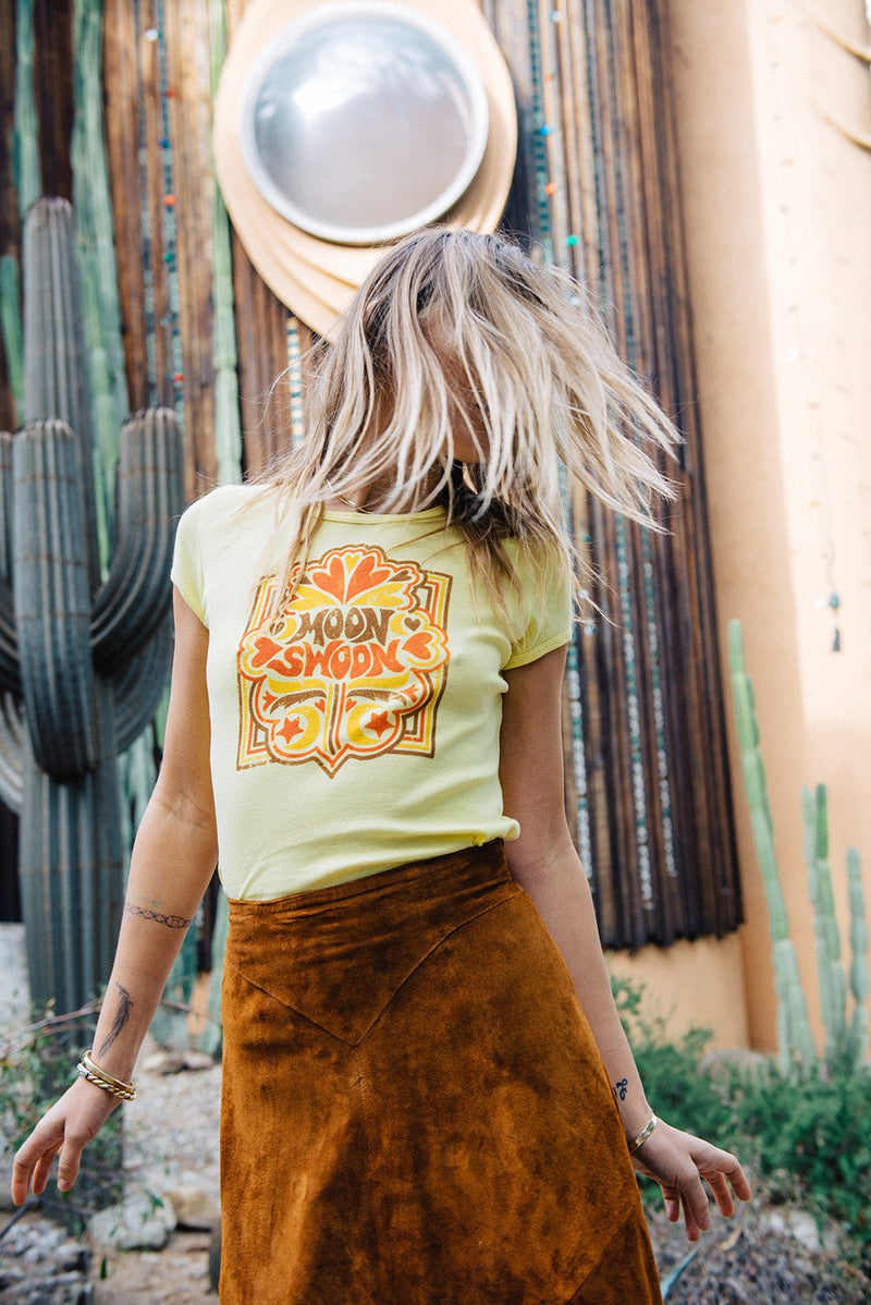 Girl shaking her hair wearing yellow Moon Swoon vintage inspired tee from Top Knot Goods