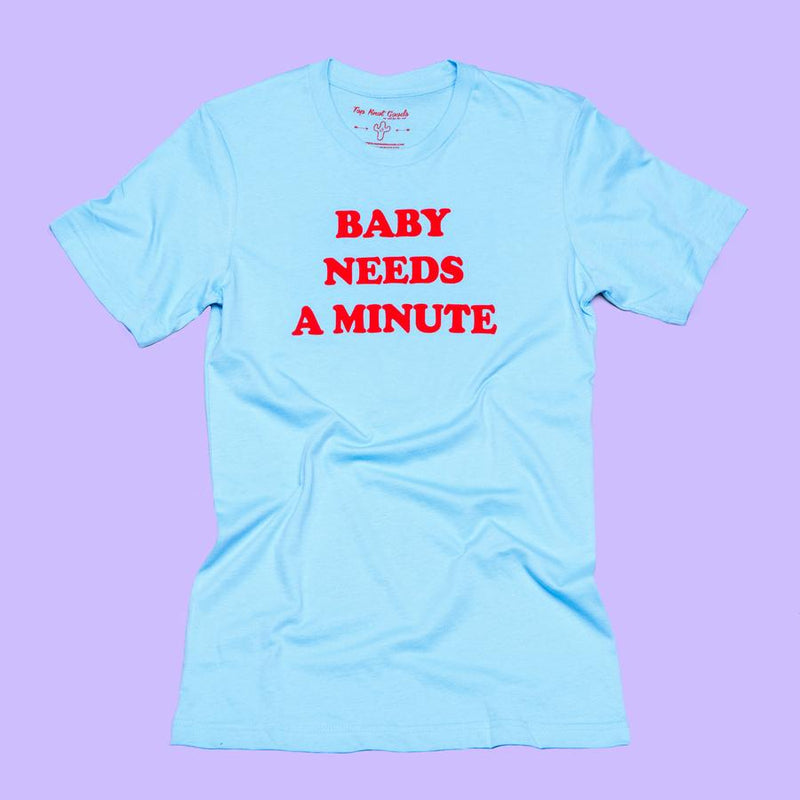 Baby Needs a Minute blue t-shirt with red text by Top Knot Goods